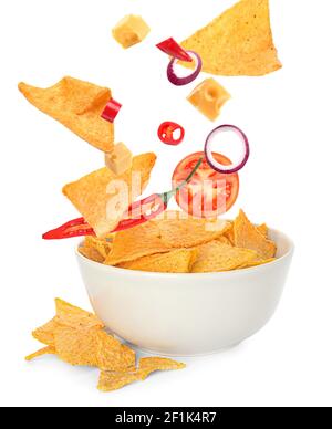 Flying nachos with ingredients and bowl on white background Stock Photo