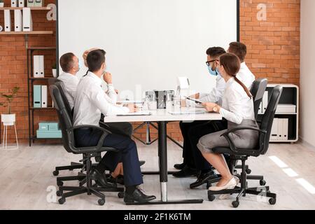 Business people having meeting in office during coronavirus epidemic Stock Photo