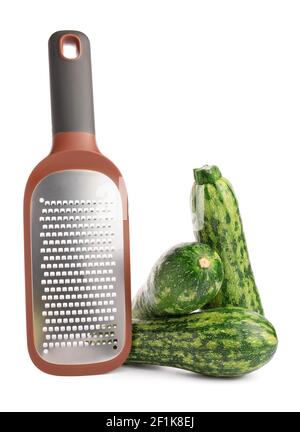 Metal grater and zucchini on white background Stock Photo