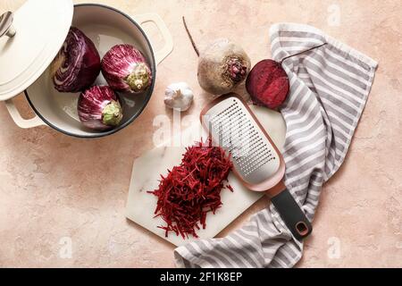 Board with grated beetroot and grater on color background Stock Photo