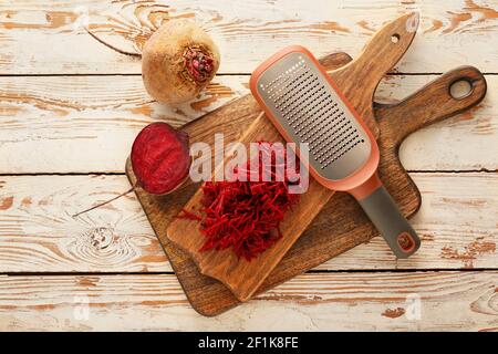 Fresh beetroot and grater on wooden table Stock Photo