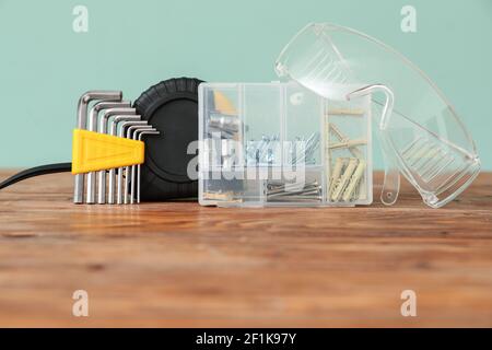 Set of construction tools on wooden table against color background, closeup Stock Photo