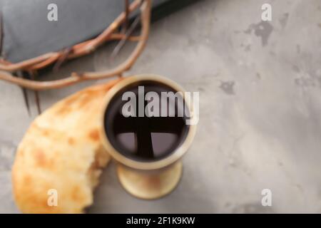 Reflection of cross in chalice of wine on table Stock Photo