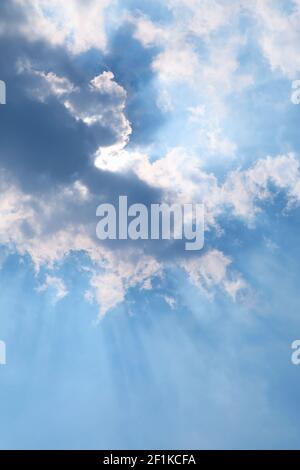 Vertical Image of Sunbeam Shining Through the Clouds on the Beautiful Blue Sky Stock Photo