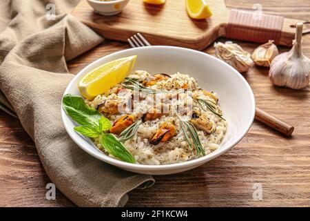 Plate with tasty risotto on wooden background Stock Photo