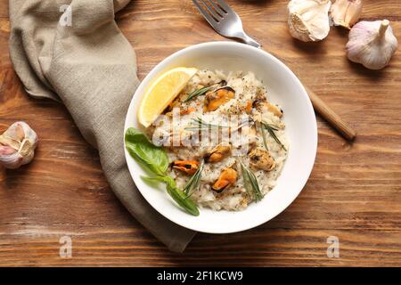 Plate with tasty risotto on wooden background Stock Photo