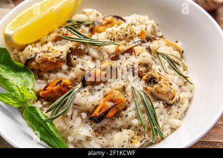 Plate with tasty risotto on wooden background, closeup Stock Photo