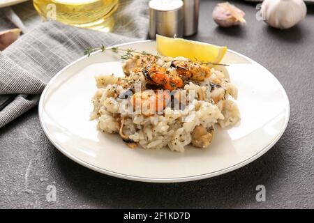 Plate with tasty risotto on dark background Stock Photo