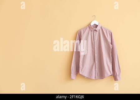Hanger with shirt on color background Stock Photo