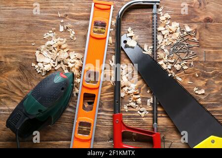 Set of carpenter's tools and saw dust on wooden background Stock Photo
