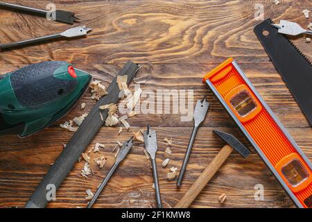 Set of carpenter's tools and saw dust on wooden background Stock Photo