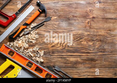 Set of carpenter's tools and saw dust on wooden background Stock Photo