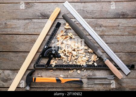 Set of carpenter's tools and saw dust on wooden background Stock Photo
