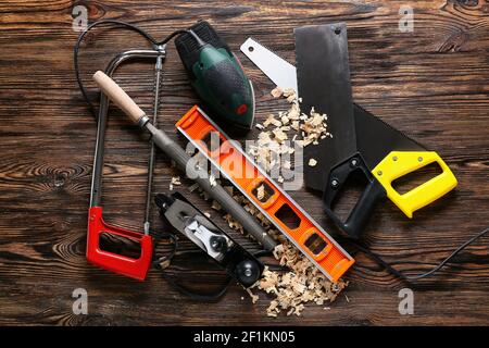 Set of carpenter's tools and saw dust on wooden background Stock Photo
