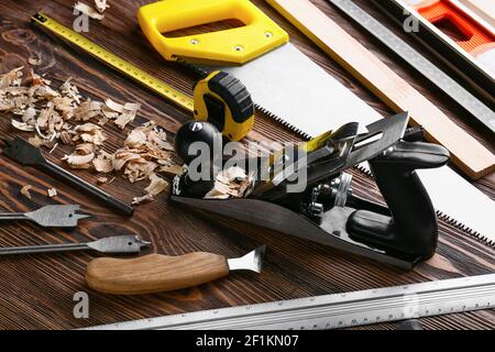 Set of carpenter's tools and saw dust on wooden background Stock Photo