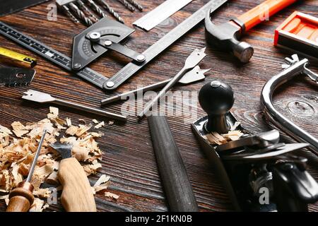 Set of carpenter's tools and saw dust on wooden background Stock Photo