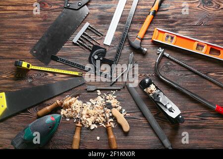 Set of carpenter's tools and saw dust on wooden background Stock Photo