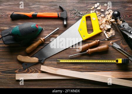 Set of carpenter's tools and saw dust on wooden background Stock Photo