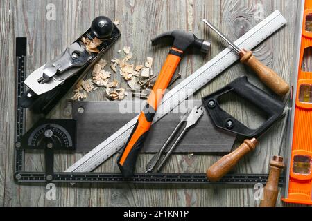 Set of carpenter's tools and saw dust on wooden background Stock Photo