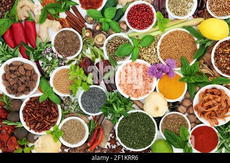 Large collection of herb and spice fresh and dried seasoning in porcelain bowls and loose. Flat lay, top view. Stock Photo