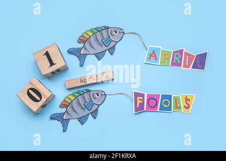 Paper fishes and calendar with date of April Fools Day on color ...