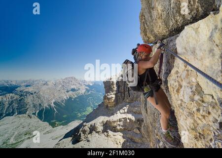 Two women mountain climbers on an exposed Via Ferrata in the Dolomites of Italy Stock Photo