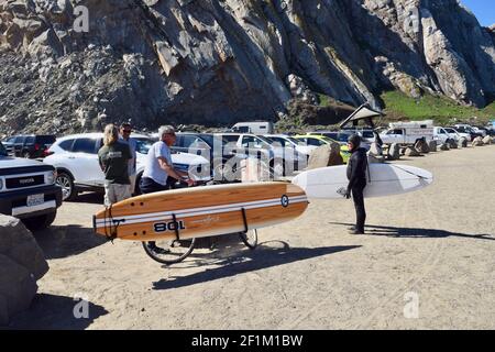 FRESNO, UNITED STATES - Mar 01, 2021: A photo of Older Surfer friends talking with their retro Surfboards at Morro Bay Rock in Ca. on a sunny day Marc Stock Photo