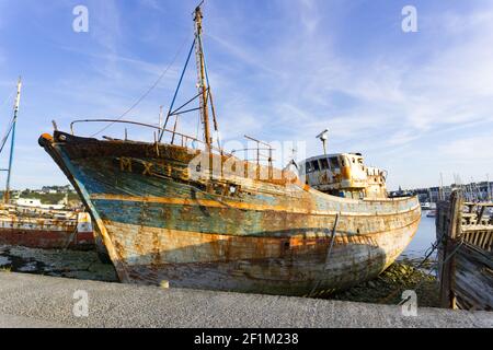 Old fishing boat wrecks stranded and left on a rocky beach Stock Photo ...