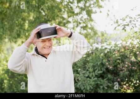 Man in park using VR headset Stock Photo