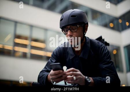 Bicycle courier using cell phone Stock Photo