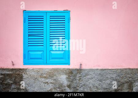 Pink wall with blue window shutter Stock Photo