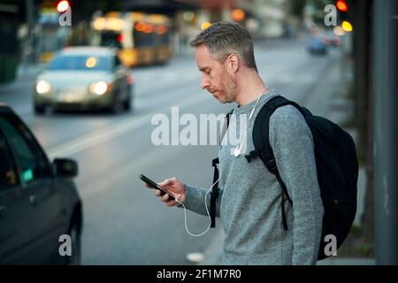 Man on street holding phone Stock Photo