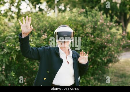 Woman in park using VR headset Stock Photo