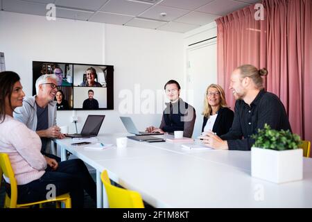 People in boardroom having video conference Stock Photo
