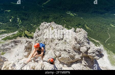 Two women mountain climbers on an exposed Via Ferrata in the Dolomites of Italy Stock Photo