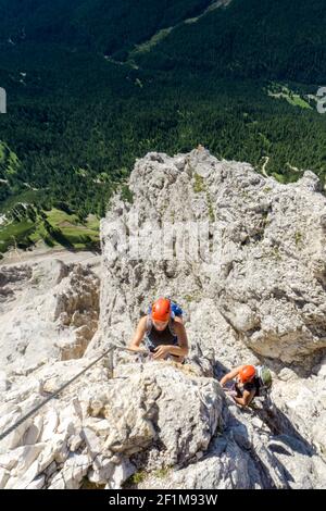 Two women mountain climbers on an exposed Via Ferrata in the Dolomites of Italy Stock Photo