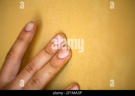 Close-up of hand on yellow background Stock Photo