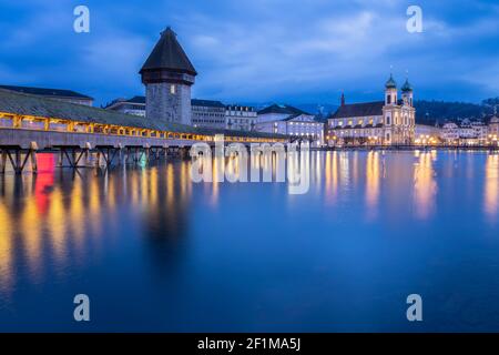 View of the Kapellbrücke bridge, the Jesuit Church and the Wasserturm reflected on the Reuss river. Lucerne, canton of Lucerne, Switzerland. Stock Photo