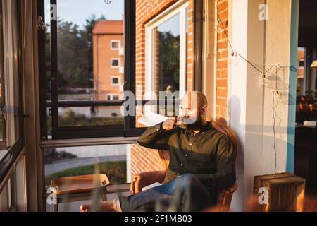 Man having coffee on balcony Stock Photo