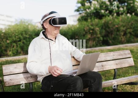 Man in park using VR headset Stock Photo