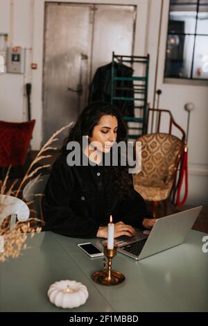 Young woman using laptop in cafe Stock Photo