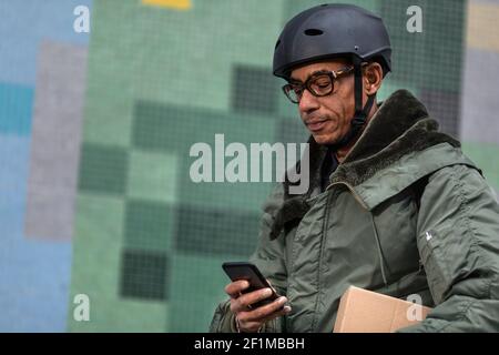 Bicycle courier using cell phone Stock Photo