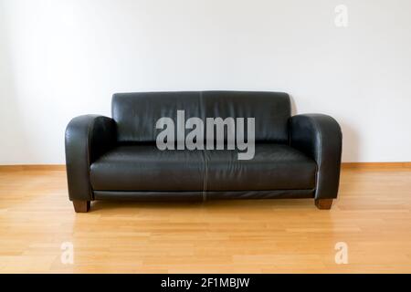 Horizontal view of a dark brown leather couch in a minimalist apartment Stock Photo