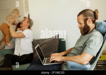 Man sitting on chair and using laptop Stock Photo