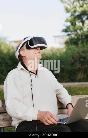 Man in park using VR headset Stock Photo