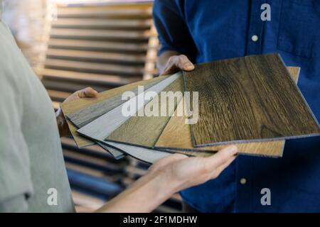 seller showing wooden texture laminate material samples to customer Stock Photo