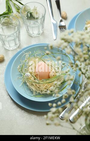 Happy Easter table setting with eggs on white textured table Stock Photo