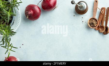 composition of red onions and spices on light blue kitchen table top view Stock Photo