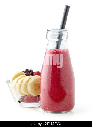 small bottle of fresh banana, pineapple juice, frozen raspberry and blueberry smoothie with black straw isolated on white background Stock Photo