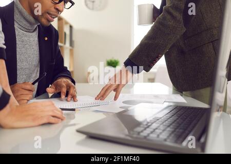 Diverse project group meeting around office desk and working on project together Stock Photo